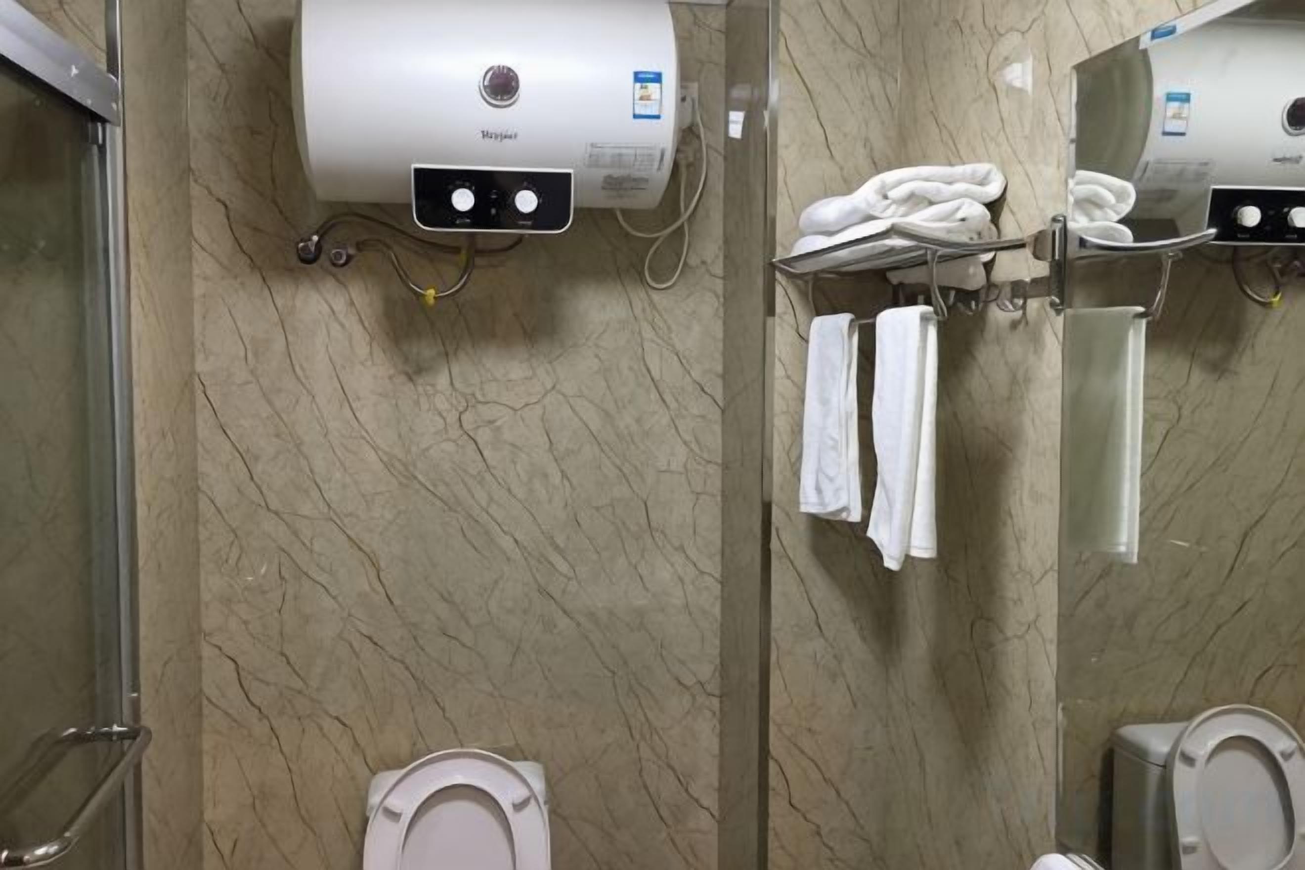 Une salle de bain équipée d’un sèche-mains, d’un porte-serviettes et de toilettes.