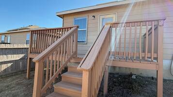A wooden staircase leading to a house with a fenced yard.