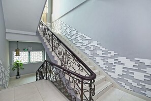 A staircase with a patterned wall and a metal railing. - Baolong Homelike Hotel (Shanghai Xuhui) (Shanghai)