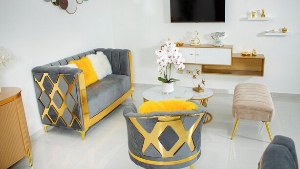 A modern living room with a grey sofa, a round coffee table, and a cushioned ottoman.