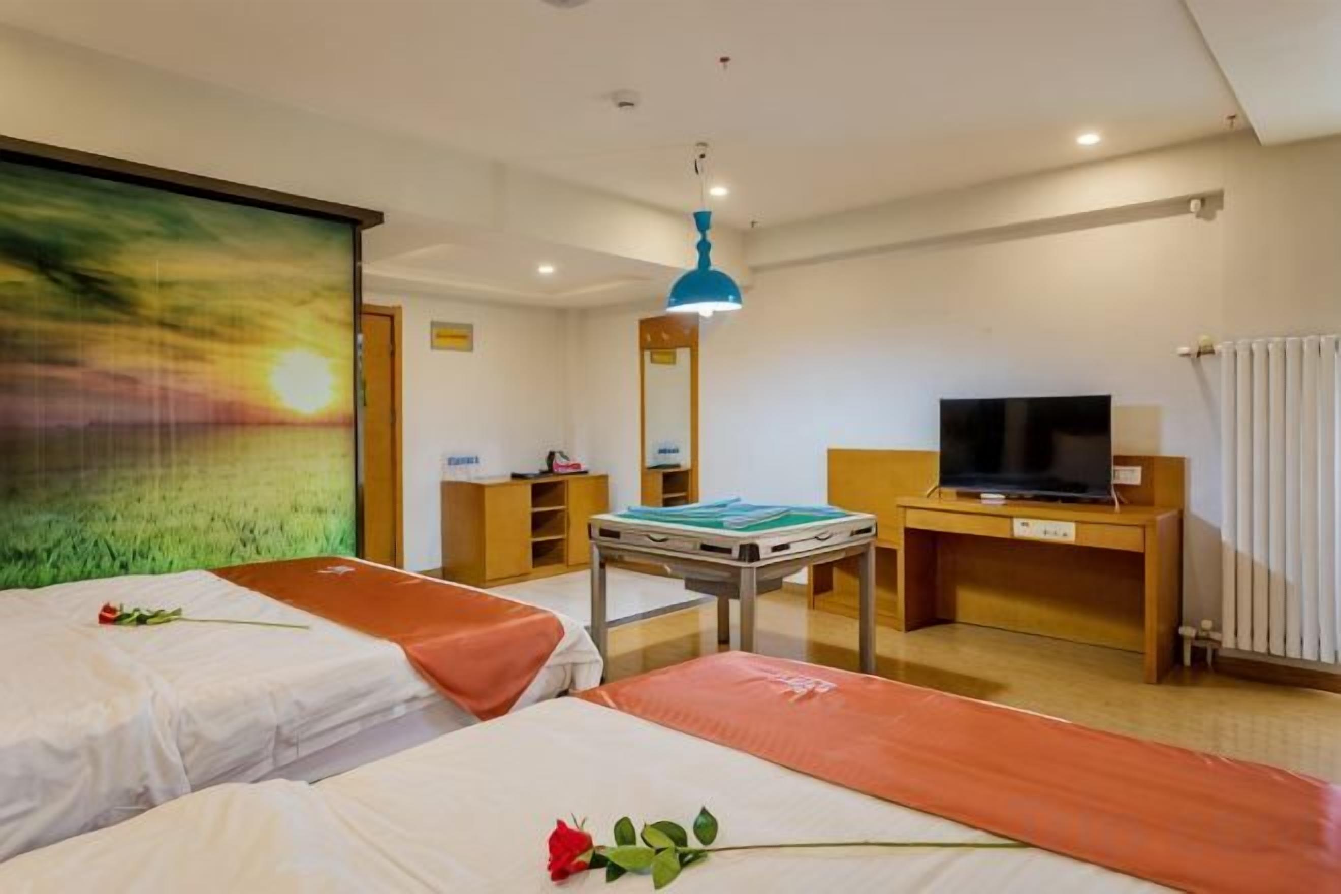 A hotel room with two beds, a desk with a television, a painting on the wall, and a window with curtains.