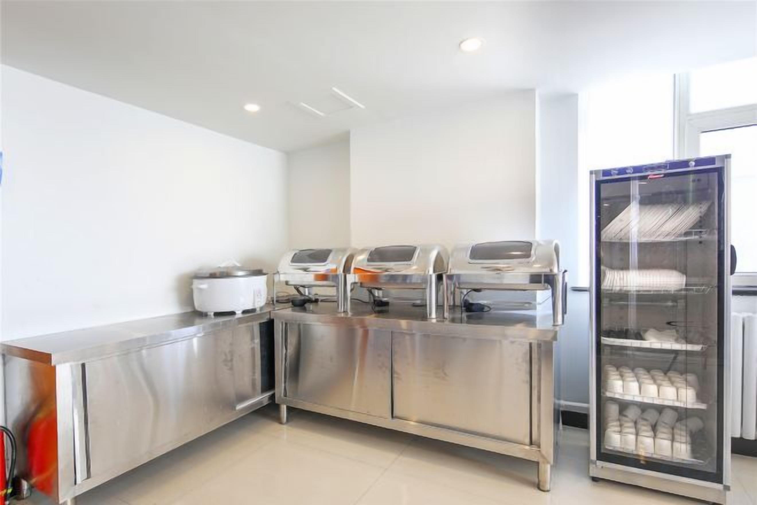 Una barra tipo bufé con mostrador de acero inoxidable y vitrina refrigerada.