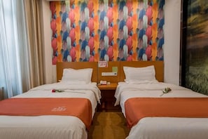 A hotel room with two beds, a wooden headboard, and a colorful wall mural.