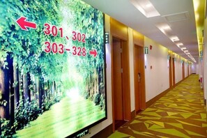 A hotel corridor with a digital display indicating room numbers 301, 302, 303-328, and a patterned floor. - Shell Hotel (Chaoyang shoe city store, Chaoyang Street, Taiyuan) (Taiyuan)