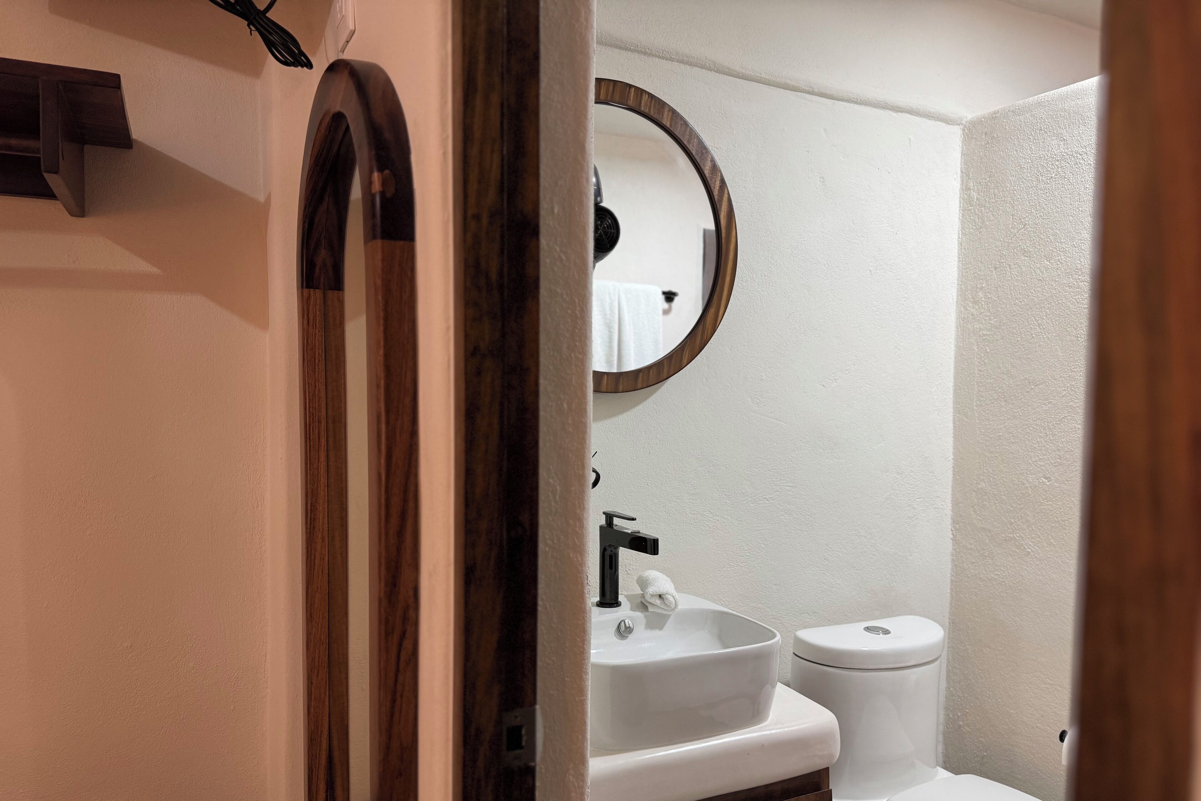 A bathroom with a white sink, a mirror, and a toilet.
