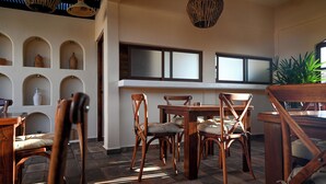A dining area with wooden furniture and a large plant.