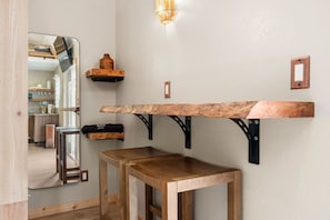 Une cuisine moderne avec des plans de travail en bois, un four encastré et un luminaire suspendu.