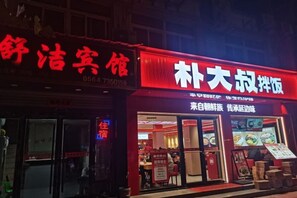 Un restaurant avec une enseigne rouge et un menu affiché à l’extérieur.