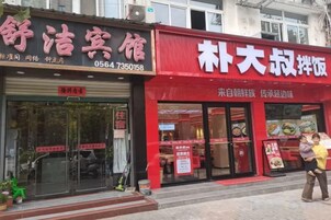 Fachada con toldo rojo y puerta de vidrio.