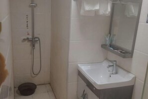 Ein Badezimmer mit Dusche, Waschbecken und Spiegel.
