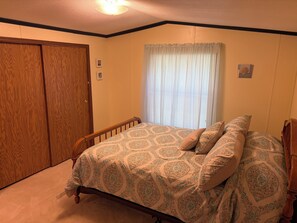Una camera da letto con un letto, un armadio in legno e una finestra con persiane.