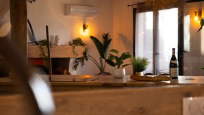 A kitchen counter with a bottle of wine, a plant, and a loaf of bread.