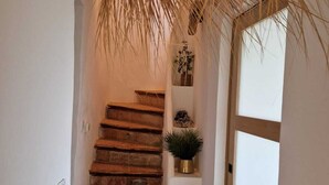 A staircase with wooden steps leading to a landing, a white wall, and a glass door.