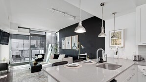 A modern kitchen with a large island, white cabinetry, and pendant lighting. - Lux Noir ATL High-rise self check-in Balcony views (Atlanta)