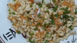 Ein Teller Pasta-Salat mit Gemüse.