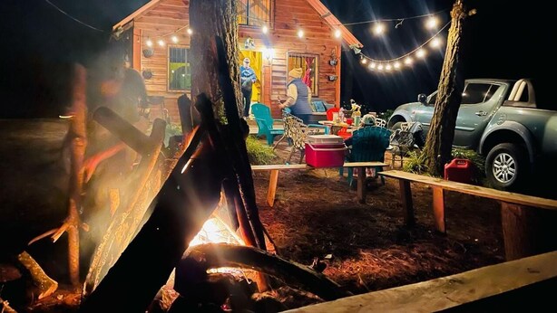 A rustic cabin with a fire pit, string lights, and outdoor seating. - Hotel y Cabañas La Posada del Cielo (La Palma)