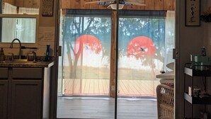Una cocina con un lavamanos, armarios y una ventana. Hay una puerta con un letrero que dice "Welcome to the Lake House".