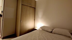 A bedroom with a bed, a wardrobe, and a nightstand. - New and with ocean view (Cartagena)