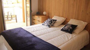 A bedroom with a bed, pillows, a nightstand, and a wooden headboard. - T2 seaside apartment - pianottoli-caldarello (Pianottoli-Caldarello)