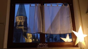 Una ventana con vista a una torre y un letrero que dice 'Merry Christmas'.