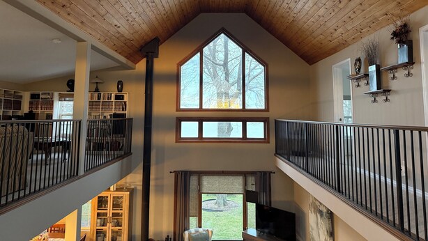 A spacious interior with a high ceiling, a large central window, and a fireplace.