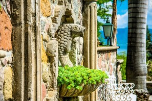 A stone fish sculpture with a planter of green plants.