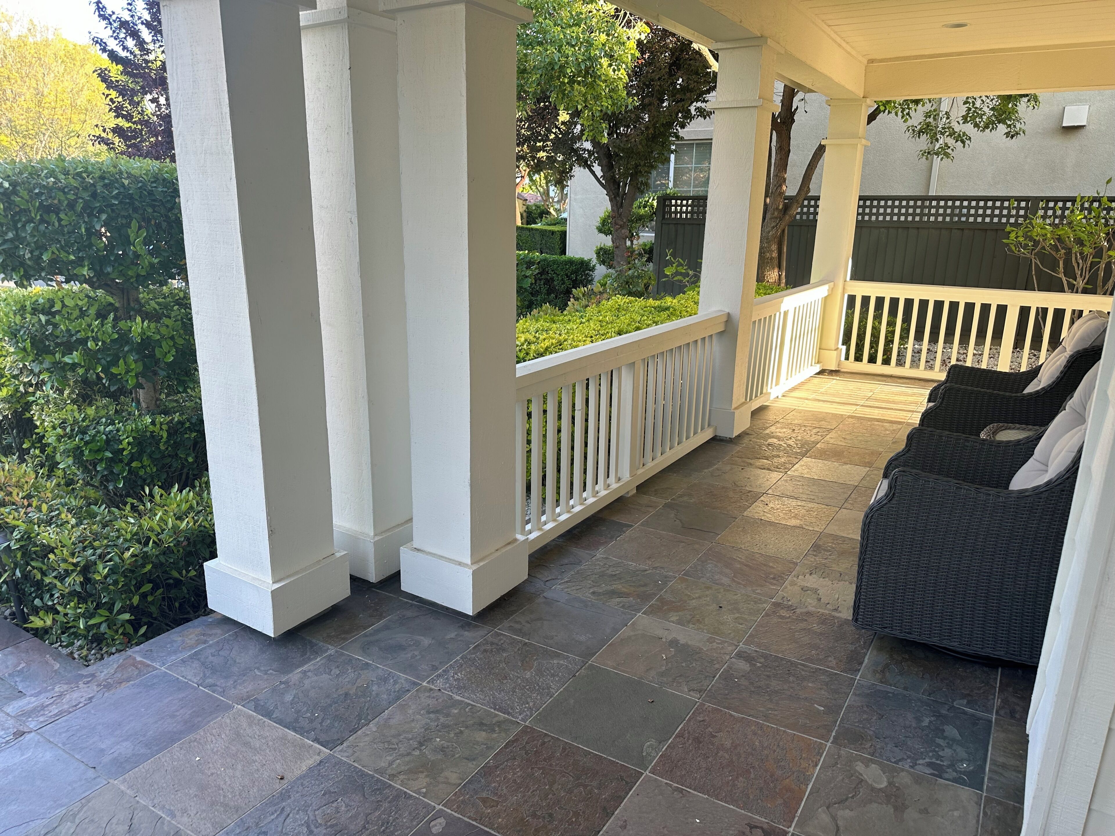 Eine überdachte Terrasse mit Sitzgelegenheit und Blick auf die grüne Umgebung.