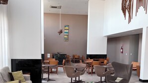 A spacious lobby with modern furniture, a flat-screen TV, and a fire extinguisher on the wall. - Luxury Apartment with Voice Automation (Barra de Jangada Jaboatão dos Guararapes)