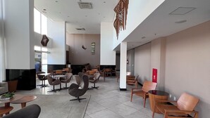 A spacious lobby with modern furniture, a large seating area, and a high ceiling with hanging decorations. - Luxury Apartment with Voice Automation (Barra de Jangada Jaboatão dos Guararapes)