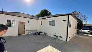 A two-story building with a flat roof, a garage, and a covered patio area.