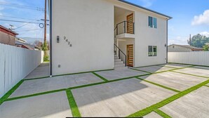 A modern two-story house with a white exterior, a visible number '2428', and a staircase leading to the upper floor. - Charming 2-bedroom apartment with WiFi, AC in beautiful Burbank (Burbank)