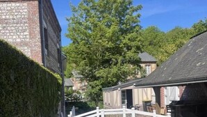A canal with a white bridge, stone buildings, and lush greenery. - Gîtes de France® - La Villa Maxence (CRASVILLE LA MALLET)