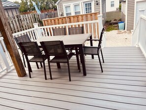 A deck with a table and chairs, surrounded by a wooden fence and a house in the background. - BAY AND BEACH
Relax in this well appointed beach cottage in historic Old Town (Somers Point)