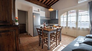 A kitchen with a dining table, chairs, and a hanging light fixture.