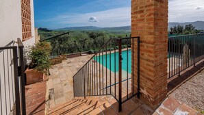 A pool area with a view of rolling hills and a clear sky.