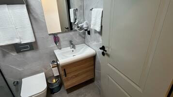 Un baño moderno con inodoro, lavamanos y tocador.