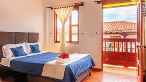 A bedroom with a bed, curtains, a window, and a balcony. - Hotel Ruta 40 Villa de Leyva (Villa de Leyva)