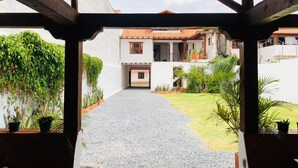 A covered outdoor area with a gravel path leading to a building with a tiled roof. - Hotel Ruta 40 Villa de Leyva (Villa de Leyva)