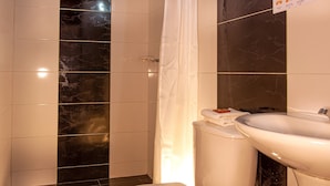 A bathroom with a toilet, sink, and shower. - Hotel Ruta 40 Villa de Leyva (Villa de Leyva)