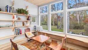 A cozy reading nook with wooden shelves, a bench, and a table.