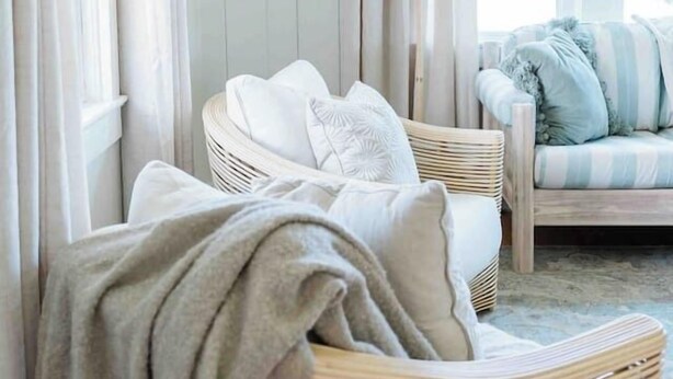 A cozy room with a wicker chair, a cushioned bench, and a striped sofa. - Hidden gem in Kure|2min walk to Beach|Hot Tub (Kure Beach)
