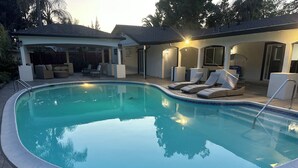A swimming pool with lounge chairs and a covered patio area. - Spacious cozy Oasis retreat with private pool  Backyard (Modesto)