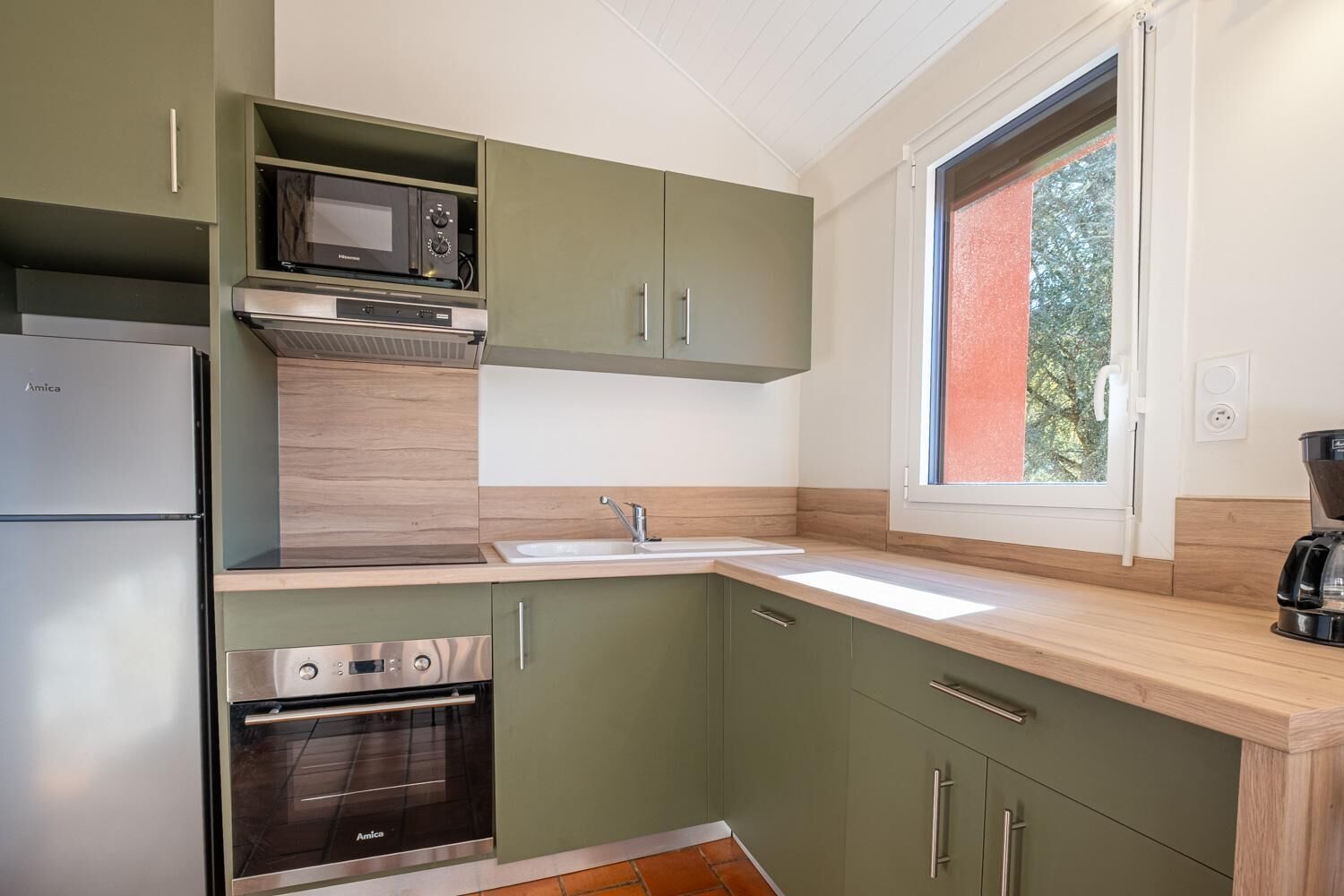 Una cocina compacta con horno integrado, microondas y pileta.