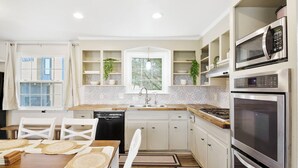 A modern kitchen with white cabinetry, a built-in microwave, and a gas stove. - Charming 5bd/4ba 15mi BNA 7mi Broadway 6mi Vandy (Nashville)