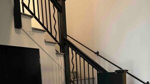 Un escalier avec des balustres noires et des marches blanches.