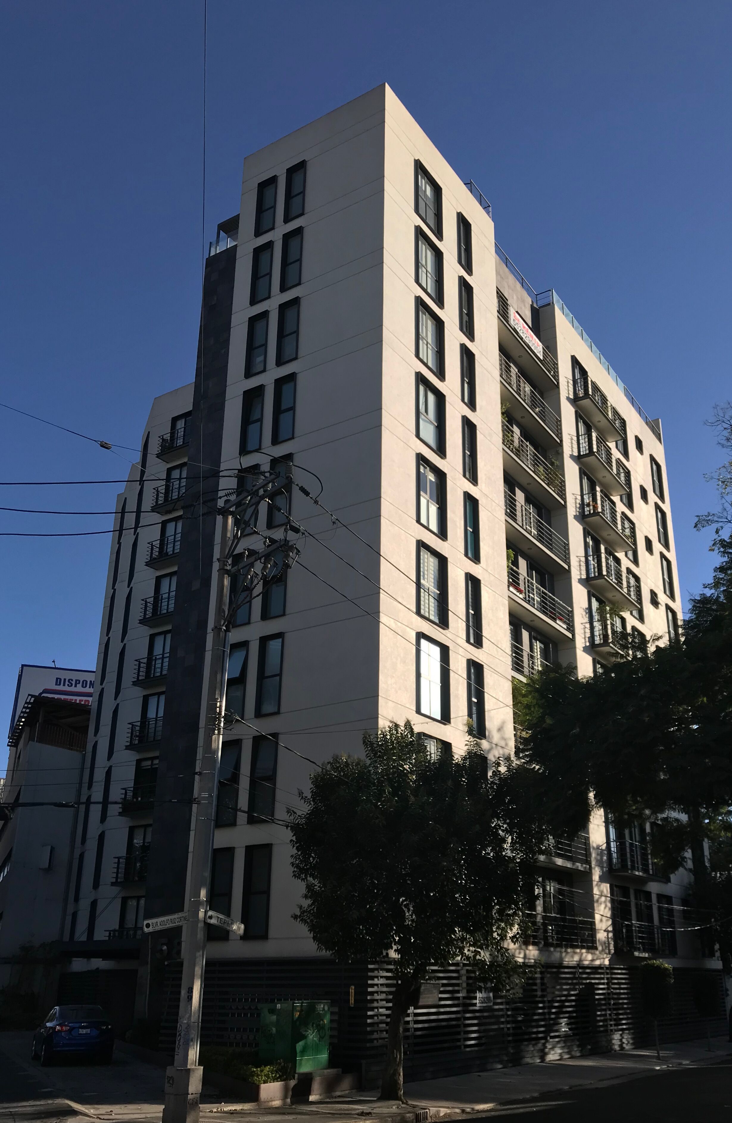 A multi-story building with a modern architectural design, featuring a series of balconies and windows.