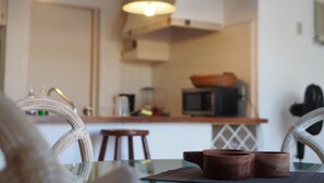 A kitchen with a microwave, a sink, and a wooden table with two brown bowls. - Apartment in Club Santiago (Manzanillo)