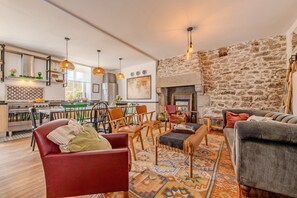 A modern living room with a fireplace, a dining area, and a kitchen. - Holiday Home 'Maison 8 Pers Plein Centre Ville' with Private Terrace, Garden & Wi-Fi (Lesneven)