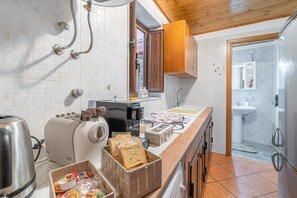 A kitchen with a toaster, coffee maker, and bread basket.