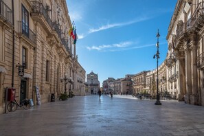 Ein weitläufiger Platz mit historischen Gebäuden, einer markanten Kirche und Flaggen.